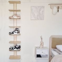 there is a shelf with shoes on it in the corner next to a bed and nightstand