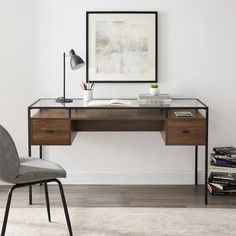 a desk with a chair next to it and a framed photograph on the wall behind it