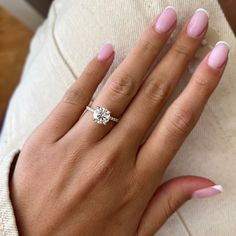 a woman's hand with pink manicured nails and a ring on her finger