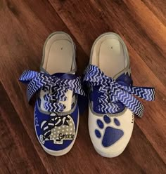 a pair of blue and white shoes with a dog's paw on it