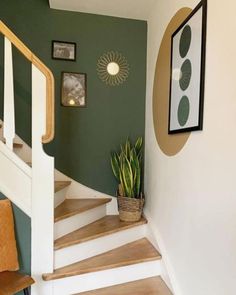 there is a potted plant sitting on the stair case next to the stairs in this house