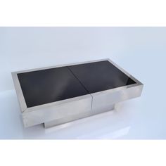 a modern stainless steel coffee table with black glass inlays on the top and bottom