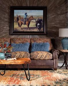 a living room filled with furniture and a painting on the wall above it's couch