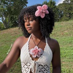 a woman wearing a crochet halter top with flowers on the front and side