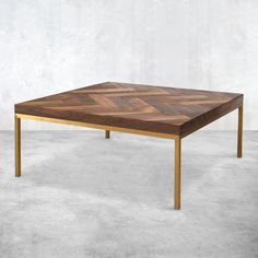 a coffee table made out of wood and metal with an angled design on the top