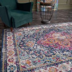 a blue chair sitting on top of a wooden floor next to a colorful area rug