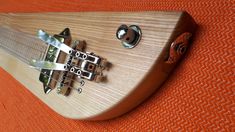 a close up of an electric guitar with strings attached to the neck and bridge, on orange fabric