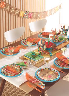 a birthday party table set up with plates and napkins