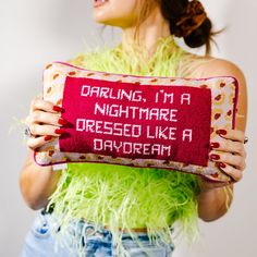 a woman is holding a pillow with writing on it that says, drooling, i'm a nightmares dressed like a daydream