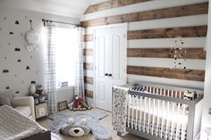 a baby's room with a teddy bear in the crib and wooden walls