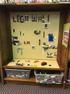 a book shelf filled with legos on top of a carpeted floor next to a bookshelf