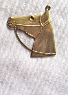 This is one raw brass stamping shaped like a horse's head. It could be used as a pendant or a large charm. The stamping was made in the USA from the same now vintage/antique tooling that made these stampings 50 to 100 years ago. The piece measures 30mm from side to side at the widest point by 35mm from the bottom to the top to bottom including the ring As is shown in a photo it is hollow backed. It is lead and nickle free. Classic Gold Jewelry With Horse Design, Vintage Silver Jewelry With Horse Design, Horse Pendant, Classic Horse Design Pendant Necklace, Brass Vintage Charm For Collectibles, Fashion Illustration Collage, Horseshoe Pendant, Victorian Pendants, Vintage Horse