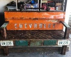 an old wooden bench with license plates on it's back and the word chevrolet written in large letters