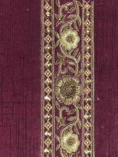 an embroidered purple cloth with gold flowers on it