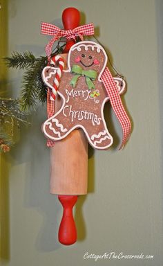 a christmas ornament hanging from the side of a wooden pole with a gingerbread man on it