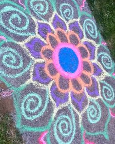 an image of a colorful design on the ground in the grass with chalk pastel