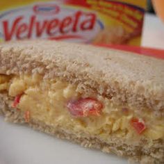 a close up of a sandwich on a plate with velveeta in the background