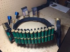 a bunch of green batteries sitting on top of a counter next to a pair of scissors