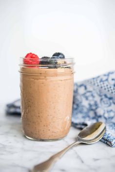 a glass jar filled with food next to a spoon