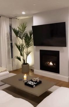 a living room filled with furniture and a flat screen tv mounted on the wall above a fire place