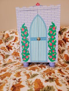 a paper cut out of a door sitting on top of a floral bed spreader