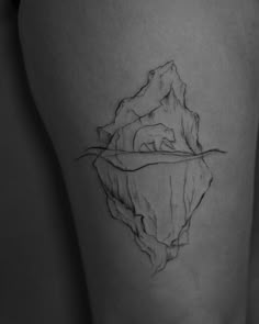 a black and white photo of a woman's thigh with an iceberg tattoo on it