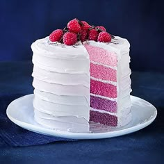 a slice of cake with white frosting and raspberries on top