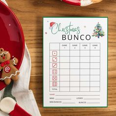 a table with a christmas bunco game next to a red plate and napkin on it