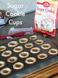 mini sugar cookie cups are sitting on a baking tray next to a bag of sugar