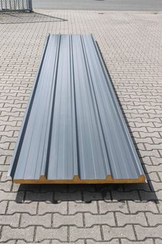 a metal roof laying on top of a brick sidewalk