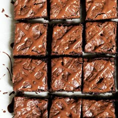 chocolate brownies with peanut butter frosting are arranged on a sheet of parchment paper