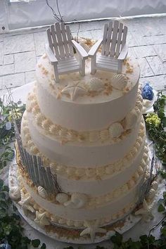 a wedding cake with two chairs on top