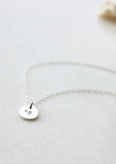 Our sweet, tiny dot stamped with one of our little symbol stamps. A solid 9mm disc is hand-stamped and attached to a delicate 18” chain. Different chain length can be requested using 'Notes' at checkout. Available in Sterling Silver and 14kt Gold Fill. Handmade in Eau Claire, WI. All of our jewelry is handmade to order just for you so each piece will be unique and may vary slightly from what is pictured. Due to its handmade nature, please allow 3-5 business days for orders to ship. Anniversary Dainty Hand-stamped Charm Necklace, Dainty Hand Stamped Initial Necklace As Gift, Dainty 14k Stamped Initial Pendant Necklace, Dainty Hand Stamped Initial Pendant Charm Necklace, Dainty Heart-shaped Hand Stamped Charm Necklace, Poppy Ring, Everyday Wear Jewelry, Dot Necklace, Unique Silver Jewelry