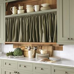 a kitchen with green cabinets and dishes on the counter top, including broccoli