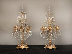 two golden candelabra with crystal chandeliers