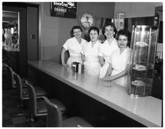 black and white photograph of four women behind the counter