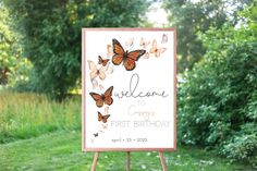 a welcome sign with butterflies on it in front of some trees and grass, along with the words'welcome to our first birthday '