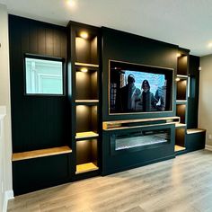 a large entertainment center with built - in shelving and lights on the side wall