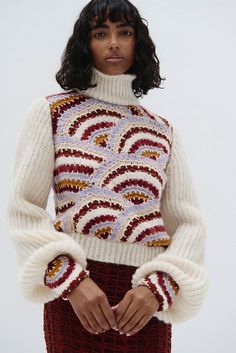 This bold sweater is made from a beautiful blend of alpaca and cotton, expertly crafted for sustainable fashion and ultimate comfort. This hand-knit masterpiece features a rich design, with voluminous sleeves, making it the perfect statement piece for the colder seasons. It features a high, ribbed turtleneck that offers cozy warmth while elongating the neck for a sophisticated silhouette. The natural softness of alpaca paired with the durability of cotton ensures warmth, breathability, and a uni Chic Multicolor Winter Sweater, Rich Design, Alpaca Sweater, High Waist Fashion, Ribbed Turtleneck, Cardigan Top, Crochet Details, Pima Cotton, Haiti