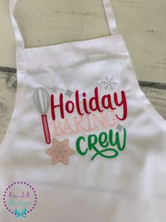 a white apron with the words holiday baking crew on it and a hot air balloon