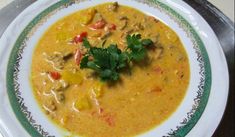 a white bowl filled with soup and garnished with cilantro