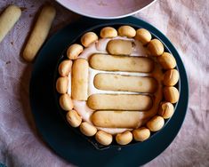 a cake is decorated with cookies and icing on a plate next to a bowl