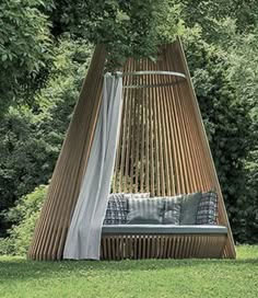 a wooden swing bed in the middle of some grass