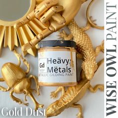 a jar of gold metallic paint sitting on top of a table next to a mirror