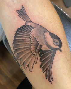 a black and white bird tattoo on the arm