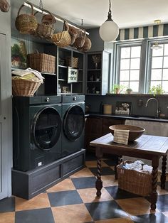 a kitchen with a checkered floor and lots of baskets hanging from the ceiling above it