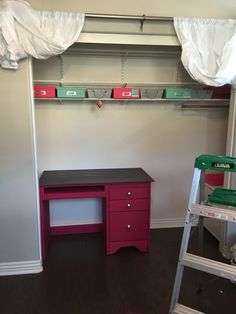 there is a pink desk in the corner of this room with shelves and ladders