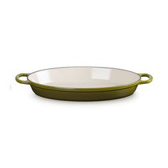 a green and white oval dish on a white background with an empty bowl in the middle