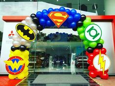 an entrance to a store decorated with balloons and superheros on the front door,