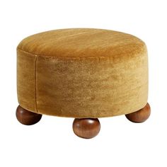 a round foot stool with wooden legs and an upholstered cushion on the top